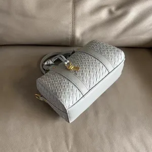 Detailed view of the woven leather Boston handbag featuring exquisite metal knot hardware.