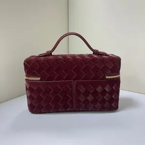 Glossy woven texture detail of the elegant burgundy vanity handbag featuring a sturdy top handle.