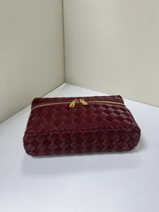 Glossy woven cosmetic bag with golden dual zippers, premium texture chic design handbag for women.
