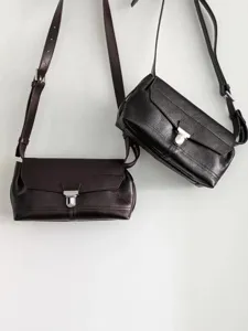 Leather crossbody messenger bag detail, vintage shoulder bag with metal lock and strap.