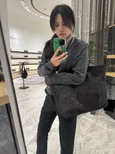 Large black woven tote bag minimalist casual shoulder bag for women daily commute.