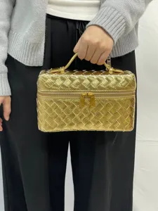 Metallic woven cosmetic handbag with top handle and double zipper closure for women daily use.