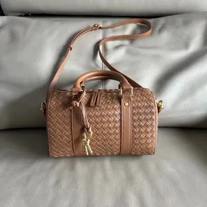 Detailed shot of the brown woven leather boston bag, showing exquisite craftsmanship and texture.