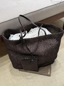 Detail view of dark brown woven tote bag, large capacity minimalist design with pouch.
