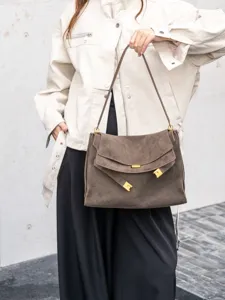 Detailed view of the brown suede shoulder bag showcasing premium hardware and texture.