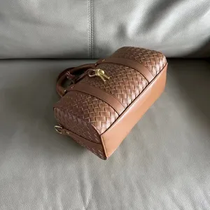 Brown woven leather Boston bag, detail view showcasing premium intrecciato texture.