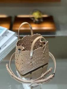 Elegant laser-cut leather tote bag with top handle and a detachable shoulder strap for women.