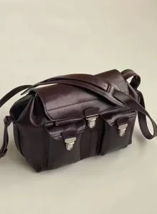Detailed view of the dark brown leather motorcycle messenger bag with dual front pockets and metal locks.