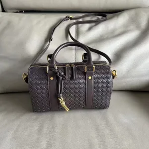 Dark brown woven leather Boston bag detail, premium textured cowhide material close-up.