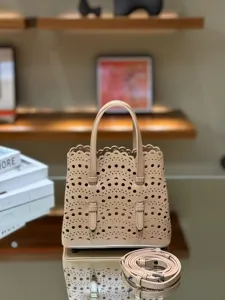 Detailed view of the chic leather laser-cut tote bag with top handles and shoulder strap.