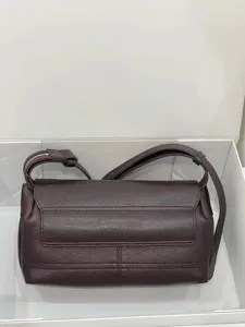 Detail shot of the dark brown leather messenger bag, showing pebble texture and fine zipper.