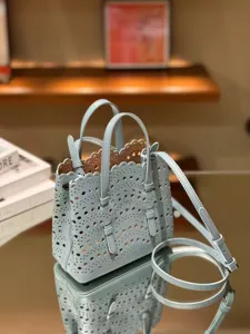 Light blue leather laser cut tote bag with top handles and shoulder strap for women fashion casual.
