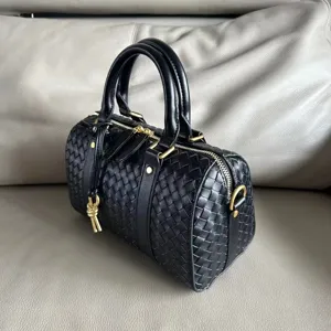 Black woven leather Boston bag detail showing intrecciato texture and dual top handles.