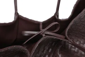 Close-up detail of dark brown woven leather tote bag showcasing premium texture and elegant strap.