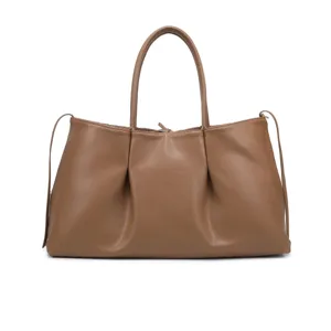 Brown leather tote bag detailed view showcasing the soft texture, dual handles, and spacious design.