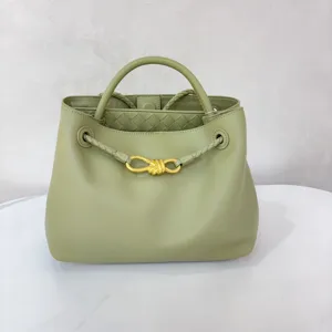 Green leather bucket bag detail showing gold knot hardware and woven interior craftsmanship.