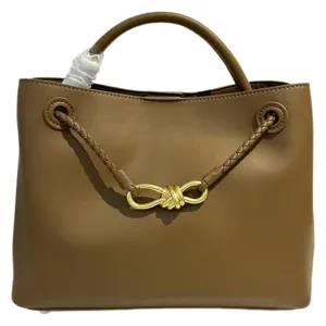 Brown leather handbag with braided strap and gold knot hardware for women daily fashion style