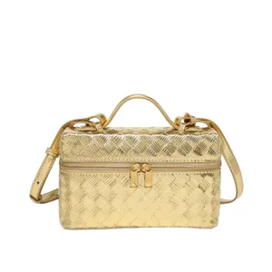 Gold metallic woven vanity bag, stylish top handle crossbody handbag for modern women.