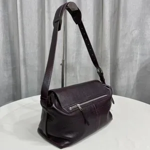 Detailed view of the dark burgundy leather messenger bag featuring adjustable strap and zipper pocket.