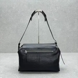 Black leather messenger bag detail, featuring metal zipper pocket and adjustable strap.