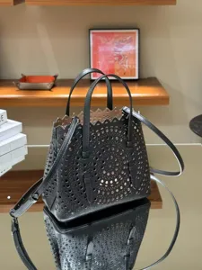Black leather laser-cut tote bag with top handles and shoulder strap for women fashion casual.