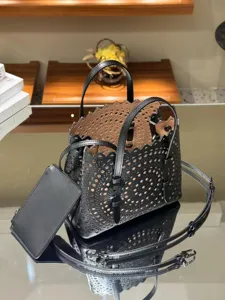 Detailed view of black leather laser-cut tote bag with scalloped edges and shoulder strap.