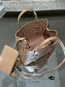 Chic laser-cut leather tote bag with matching pouch and strap, perfect for stylish everyday wear.