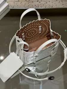 White leather laser cut tote bag detailed view, elegant scalloped edge shoulder handbag.