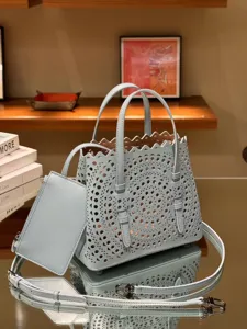 Light blue leather laser-cut tote bag detail showcasing intricate pattern and handles.