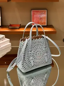 Close-up of light blue leather laser-cut tote bag with intricate geometric pattern details.