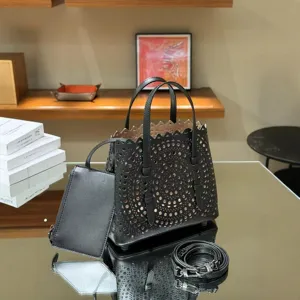 Black leather laser-cut tote bag with shoulder strap and pouch, stylish everyday handbag.