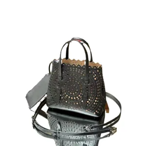 Black leather laser cut tote bag French casual chic shoulder crossbody handbag with top handle.