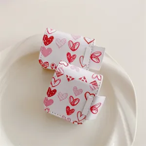 White leather doodle heart protective case for wireless bluetooth earphones, stylish design.