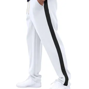 Gedetailleerd uitzicht op een witte sportbroek met zwarte zijstreep en praktische drukknopen.