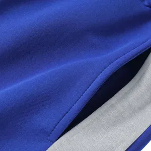 Close-up detail van heren sportbroek zak, met contrasterende stiksels en afwerking.