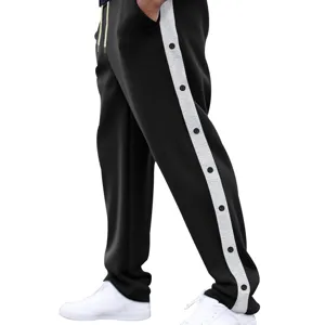 Losse heren joggingbroek met drukknoppen aan de zijkant en contrasterende strepen voor comfort.