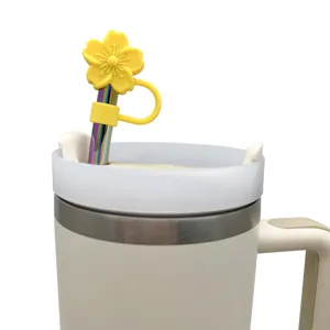 Detailed close-up of a cute yellow flower silicone straw cover with a rainbow metal straw.