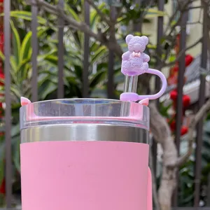 Pink tumbler detailed view featuring a cute purple bear silicone straw cover and clear lid.