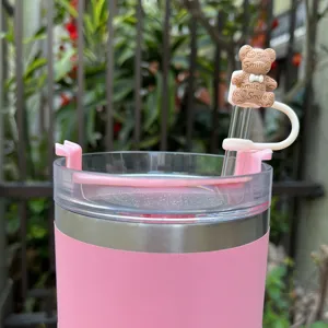 Close-up detail of the cute bow bear silicone straw topper on a pink stainless steel cup.
