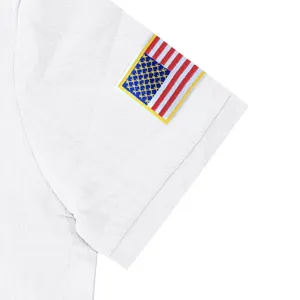 Detailed close-up shot showing the sleeve embroidery patch and breathable linen fabric texture.