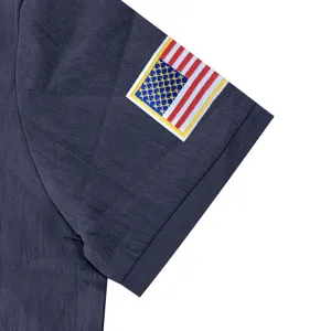 Close-up view of the short sleeve cuff with detailed American flag embroidery on dark blue fabric.