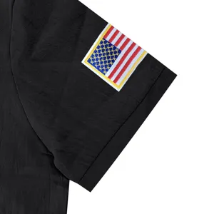 Close-up detail of black men's short sleeve polo shirt sleeve with embroidered US flag patch.