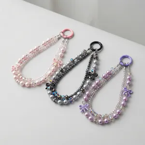 Detailed closeup view of crystal beaded phone strap with cute bows and pearl chains