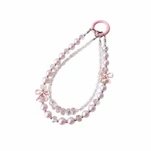 Detailed view of multi-strand beaded phone charm with pink pearls, crystals, and cute bows.