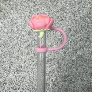 Close-up detail shot of a cute pink flower silicone straw cover topper for 10mm drink cups.