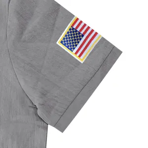 Close up of mens polo sleeve with detailed American flag embroidery and breathable grey fabric.