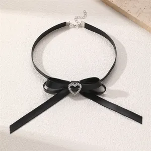 Detailaufnahme einer schwarzen Choker-Halskette mit eleganter Schleife und Strass-Herz.