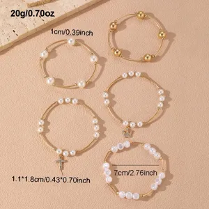 Set de pulseras apilables de perlas doradas con dijes de cruz y corona para mujer.