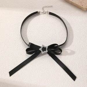 Nahaufnahme eines schwarzen Leder-Chokers mit funkelndem Strassstern-Schleifendetail.