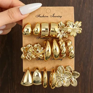 Detailansicht von 9 Paar goldenen Ohrringen mit Blumen- und geometrischen Motiven auf Karte.